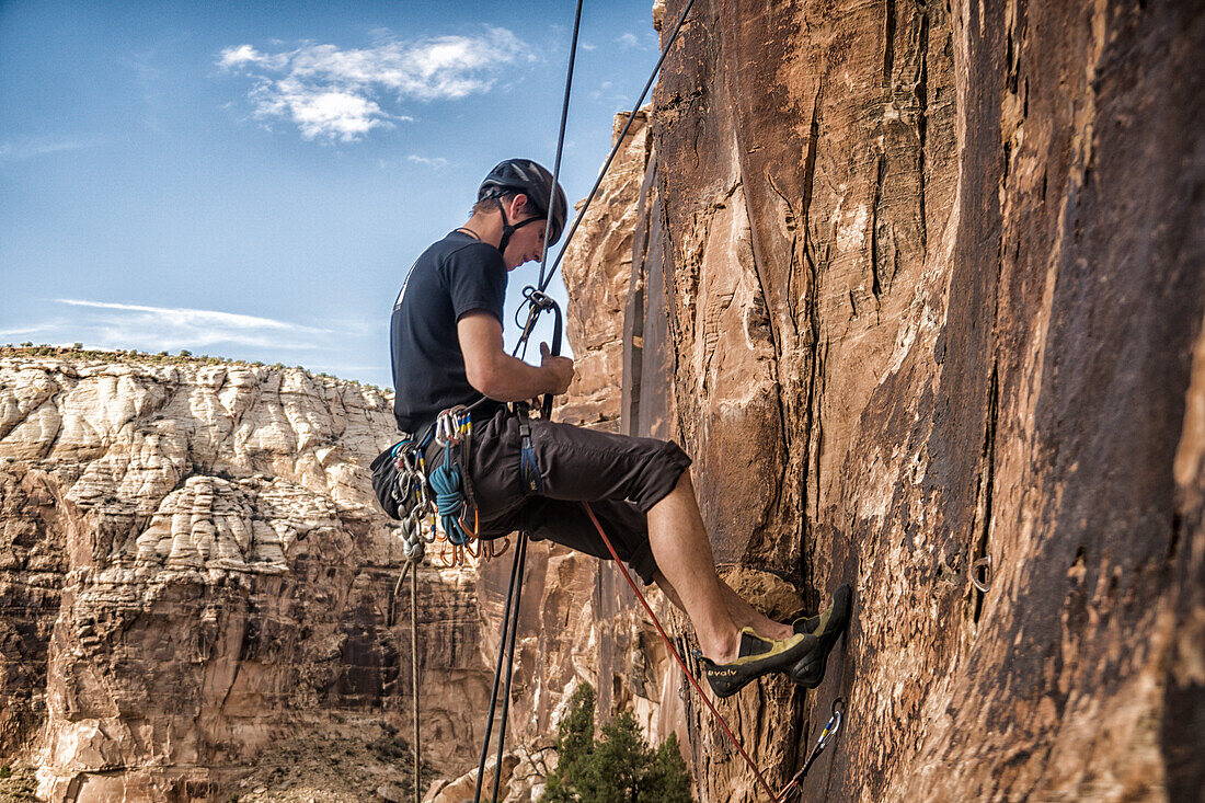 Tyler Price erklimmt eine Route im Sandstein von Buckhorn Wash im San Rafael Swell, Utah.