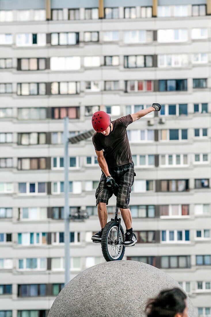 Teenager Einradfahren auf Steinkugel erfordert ein sorgfältiges Gleichgewicht