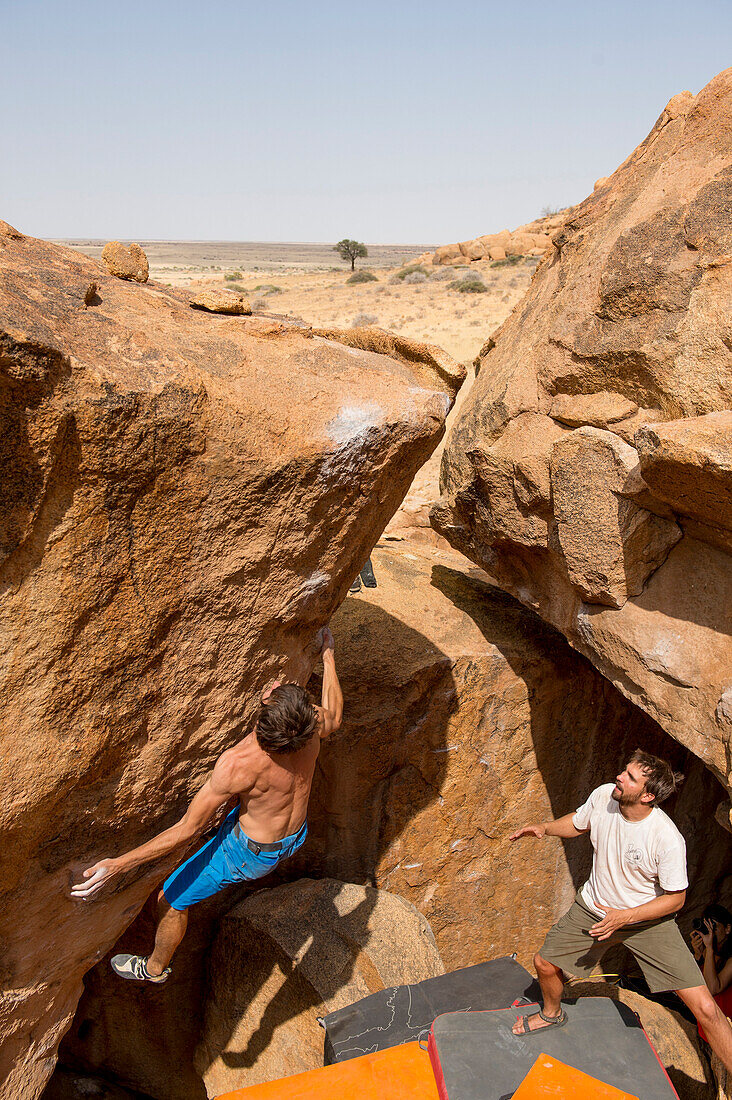 Ein Mann Bouldern und andere zuschauen, Spitzkoppe, Erongo Region, Namibia