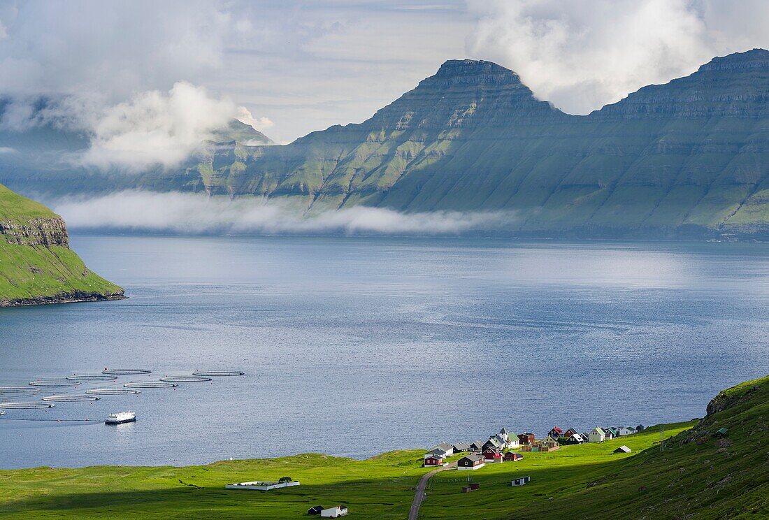 Hellur liegt am Fjord Oyndarfjordur, im Hintergrund die Berge der Insel Kalsoy. Die Insel Eysturoy ist eine der beiden großen Inseln der Färöer im Nordatlantik. Europa, Nordeuropa, Dänemark, Färöer.