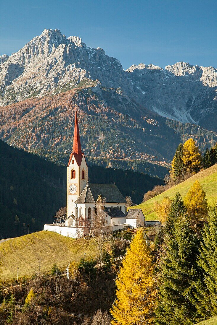 Herbstmorgen in der ikonischen Alpenkirche in Winnebach, Südtirol, Italien.