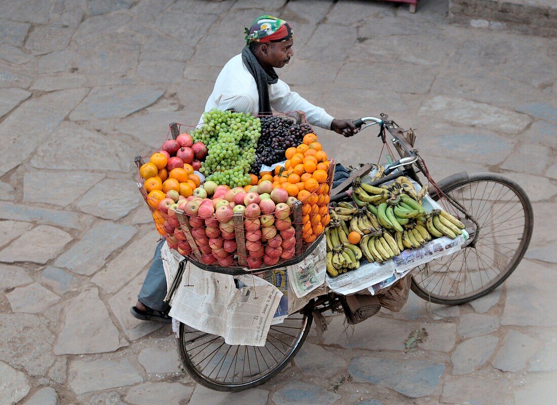 Bhaktapur, Nepal, Ein Obstverkäufer, gehen mit seinem Fahrrad in der alten Straße von Durbar sqare