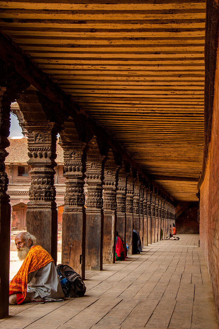 Bhaktapur, Nepal, Asia, A man relaxes in the archways of a historical building