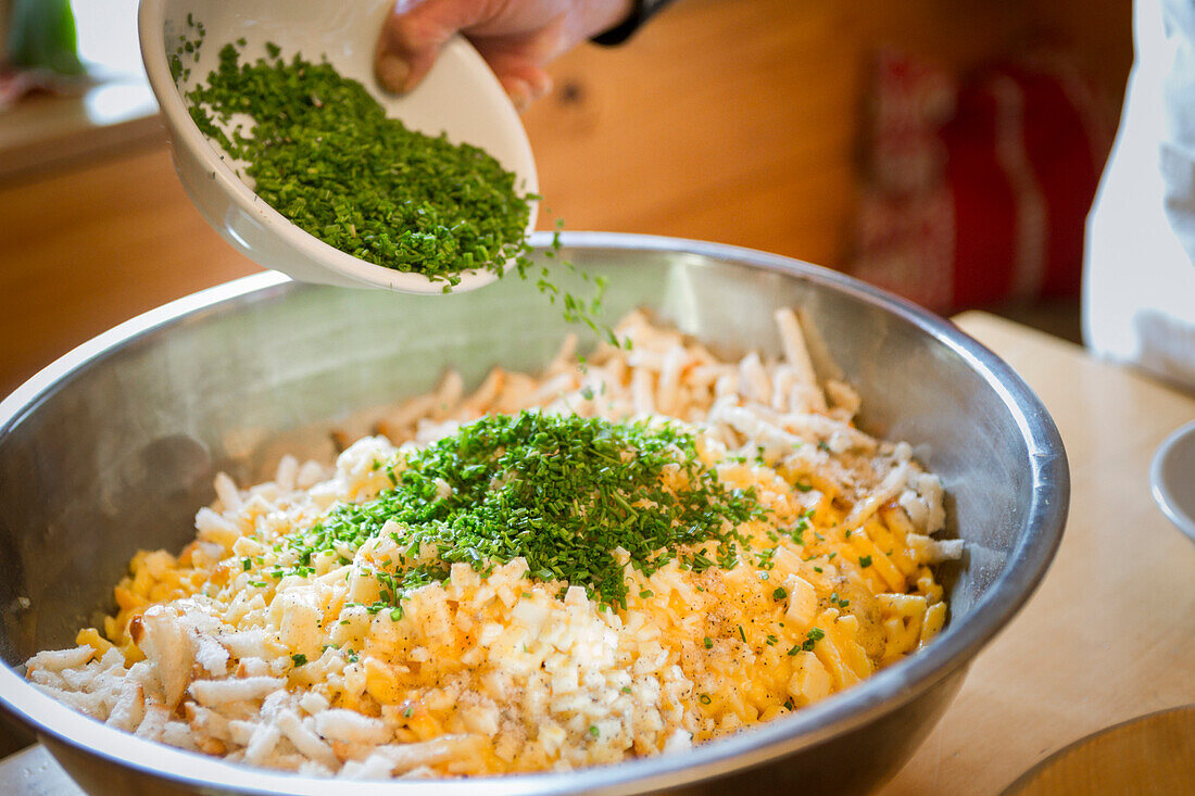 ein Koch bereitet ein traditionelles lokales Essen mit Eiern, Brot und Schnittlauch, Provinz Bozen, Südtirol, Italien