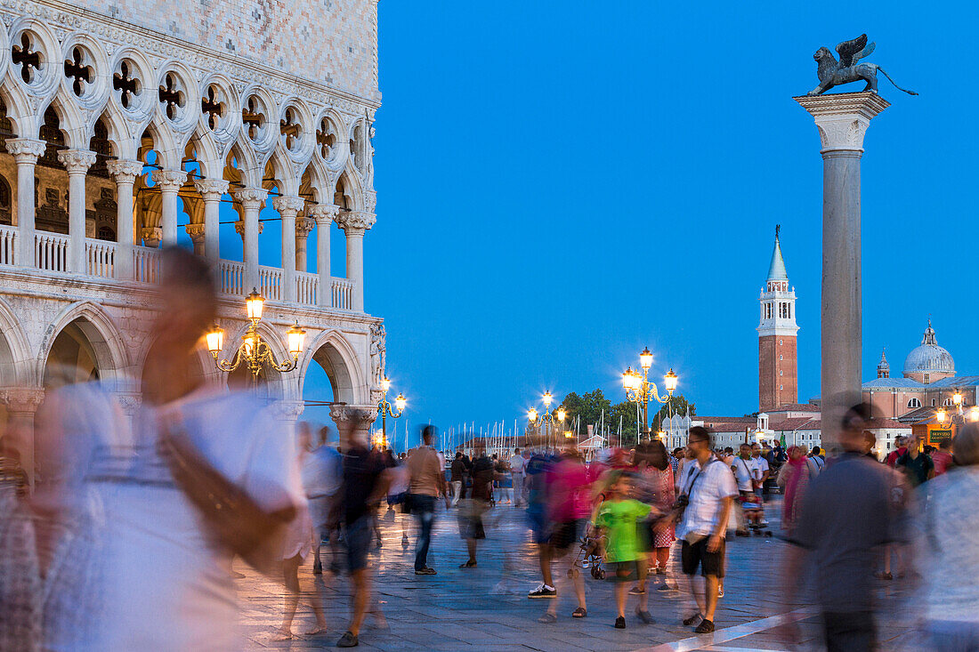 Tourists admire the historical buildings at dusk in St Mark's Square Venice Veneto italy Europe