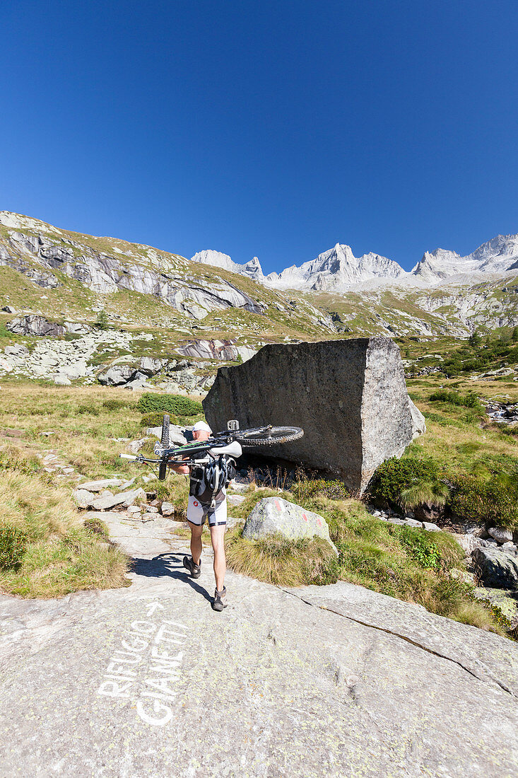 Cyclist with mountain bike ready for a ride Porcellizzo Valley Masino Valley Valtellina Sondrio Province Lombardy Italy Europe