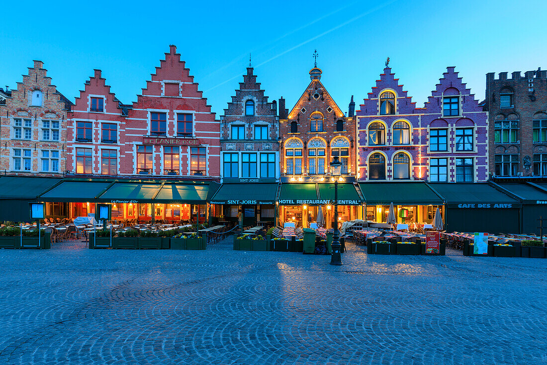 Blue lights of dusk on the colorful medieval houses in Market Square Bruges West Flanders Belgium Europe