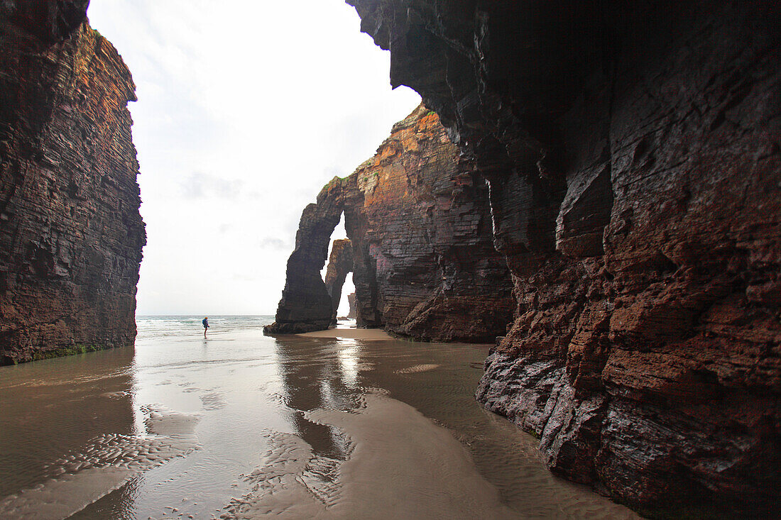 Spanien, Galizien. Ribadeo. Winzige Form zwischen sehr großen Felsen. Las Catedrales Strand.