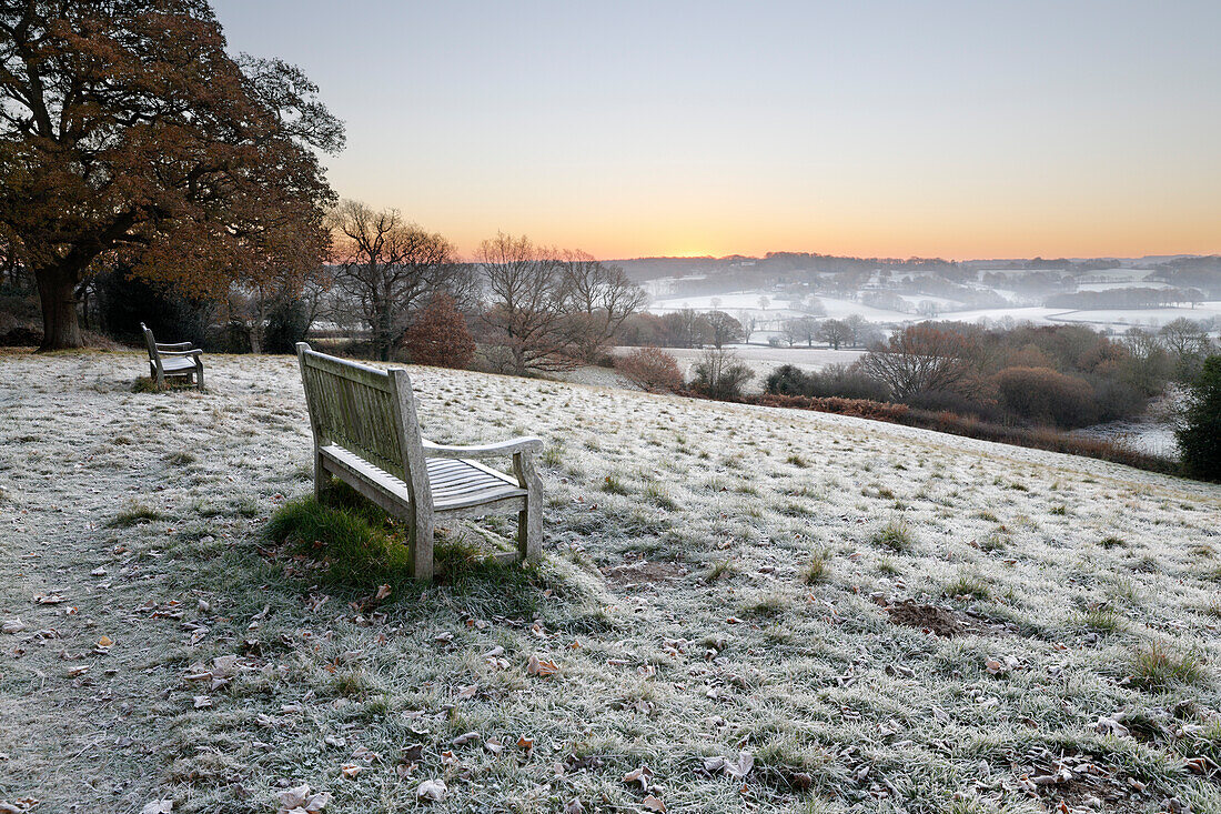Holzbank und Blick über Sussex Landschaft bei Sonnenaufgang im Frost, Burwash, East Sussex, England, Vereinigtes Königreich, Europa