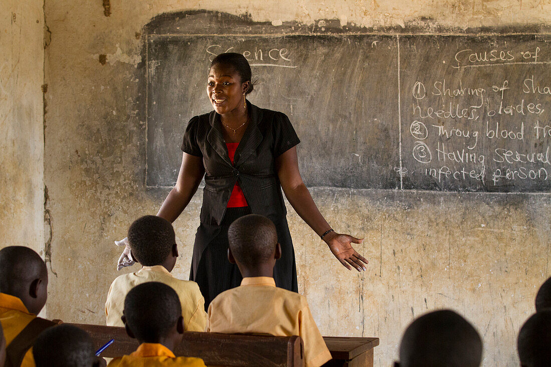 Eine Lehrerin, die einem Klassenzimmer von Schülern in einer Grundschule in Ghana, Westafrika, Afrika, Wissenschaft beibringt