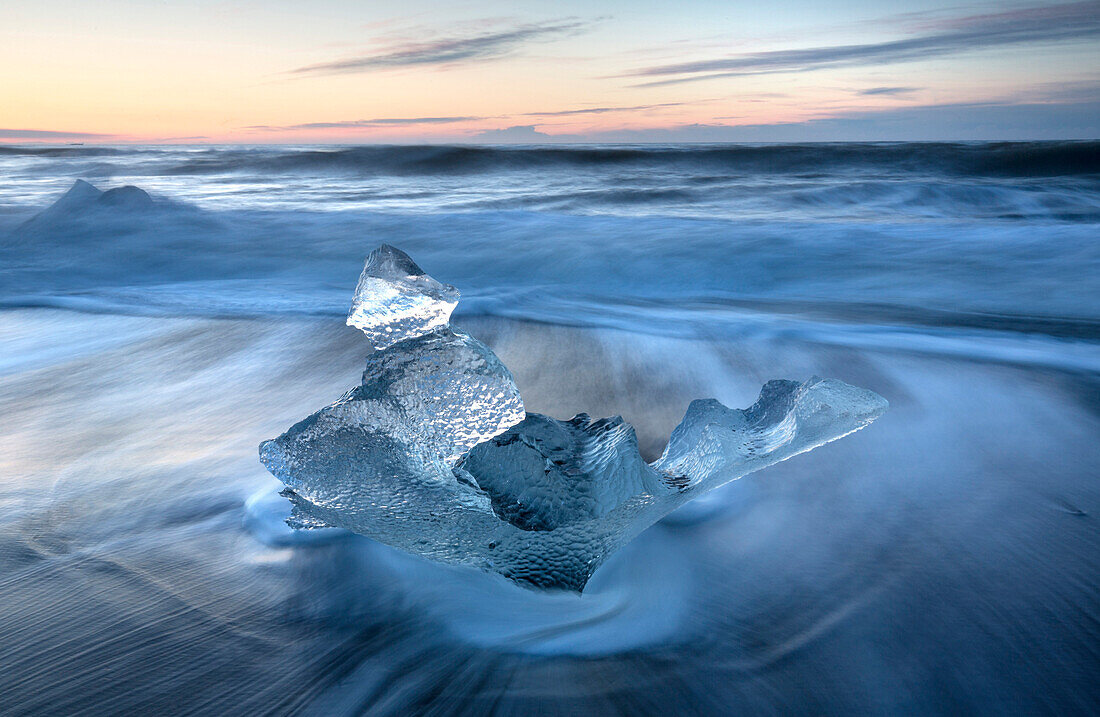 Gläserne Stücke von Eis auf vulkanischen schwarzen Sandstrand bei Sonnenaufgang, in der Nähe von Jokulsarlon Lagune, Südisland, Polargebiete