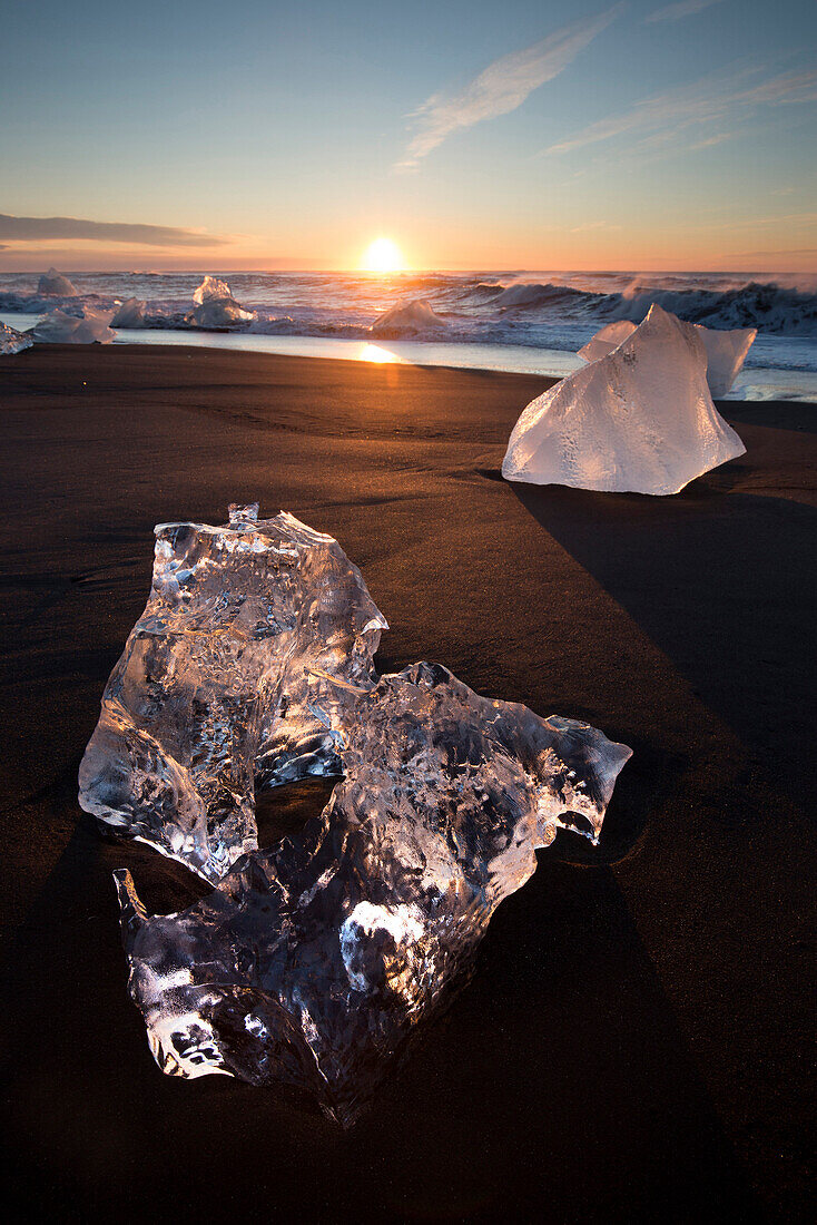 Glassy pieces of ice on volcanic black sand beach at sunrise, near Jokulsarlon Lagoon, South Iceland, Polar Regions