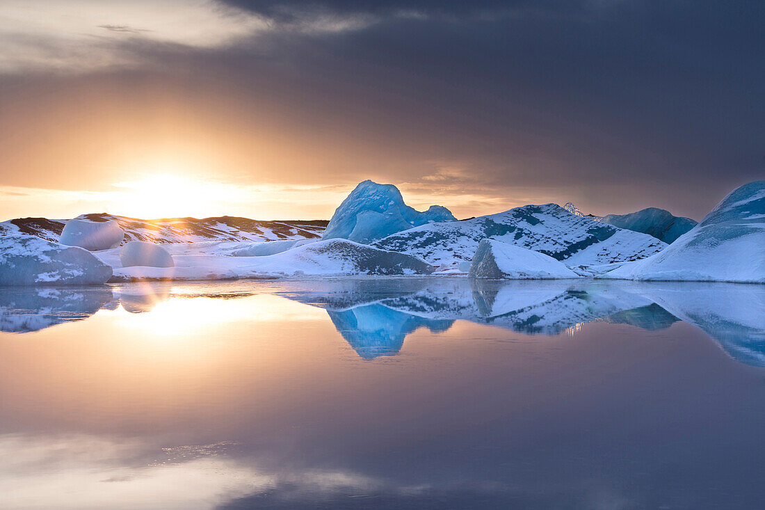 Icebergs covered in dusting of snow in winter at sunset, Jokulsarlon Glacial Lagoon, South Iceland, Polar Regions