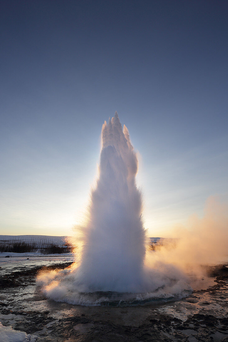 Strokkur-Geysir, der bei Sonnenaufgang im Winter ausbricht, geothermisches Gebiet neben dem Hvita-Fluss, Geysir, Island, Polargebiete