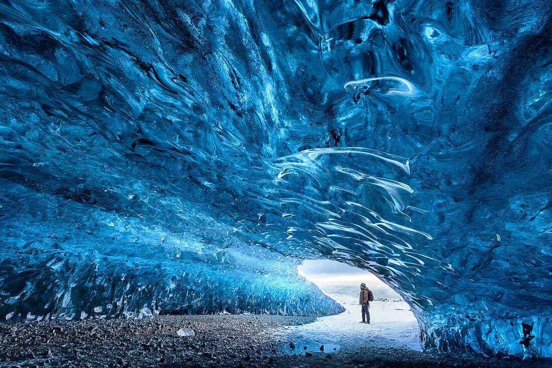 Blick von innen Eishöhle unter dem Vatnajokull-Gletscher mit Person für Skala, in der Nähe von Jokulsarlon Lagune, Südisland, Polarregionen