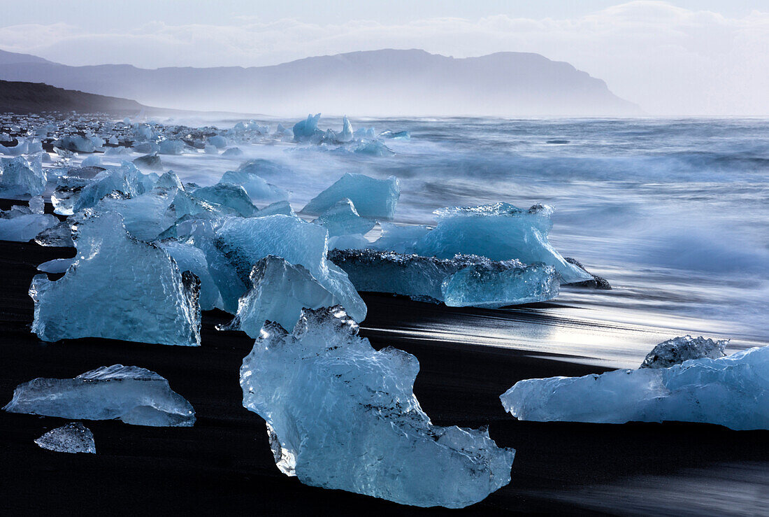 Glacial icebergs washed up from North Atlantic Ocean onto volcanic sand beach near Jokulsarlon, South Iceland, Polar Regions