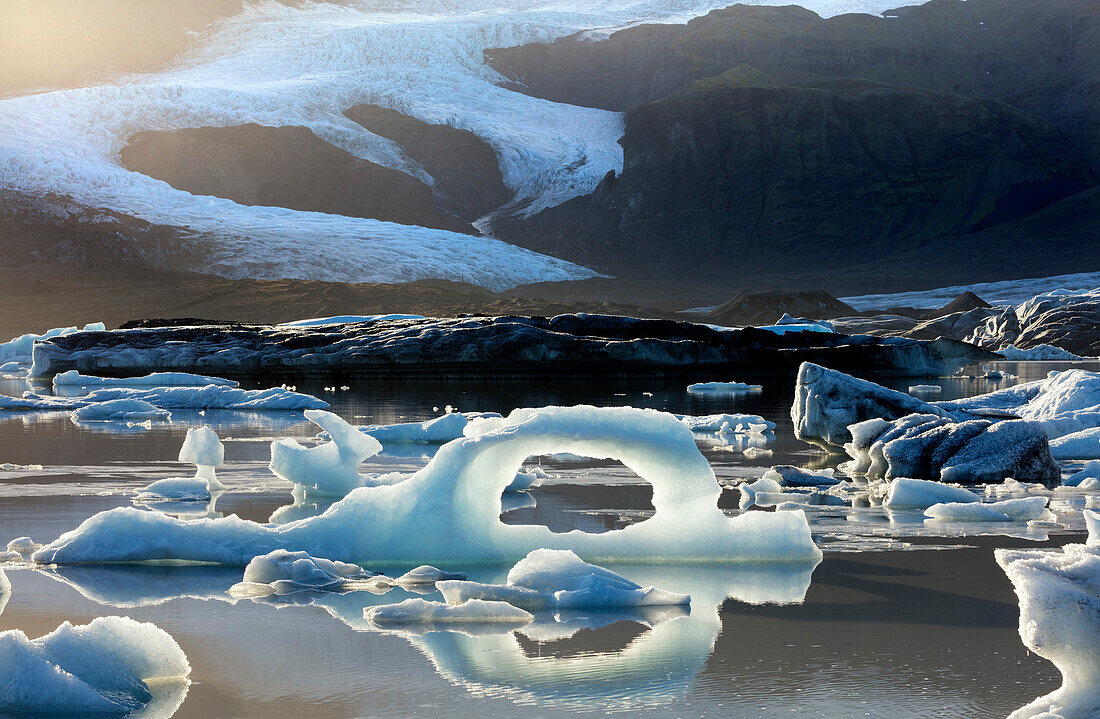 Ice arch among icebergs floating on Fjallsarlon lagoon, near Jokulsarlon, South Iceland, Polar Regions