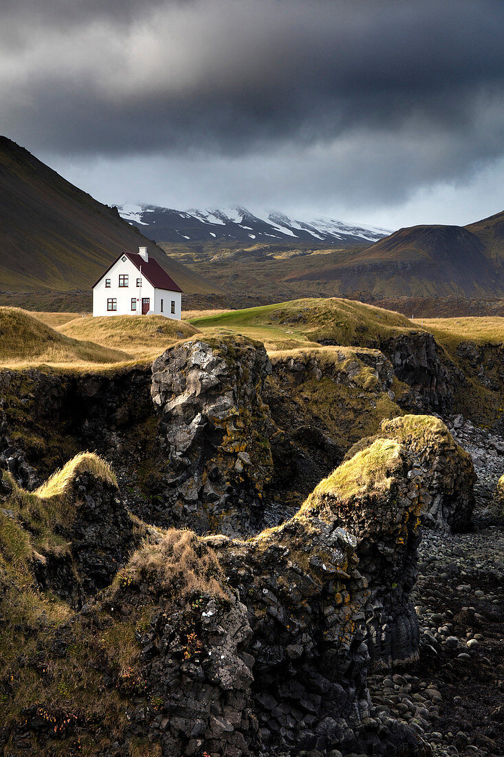 Lone house and sea stacks in stormy weather, Arnastapi, Snaefellsnes Peninsula, Iceland, Polar Regions