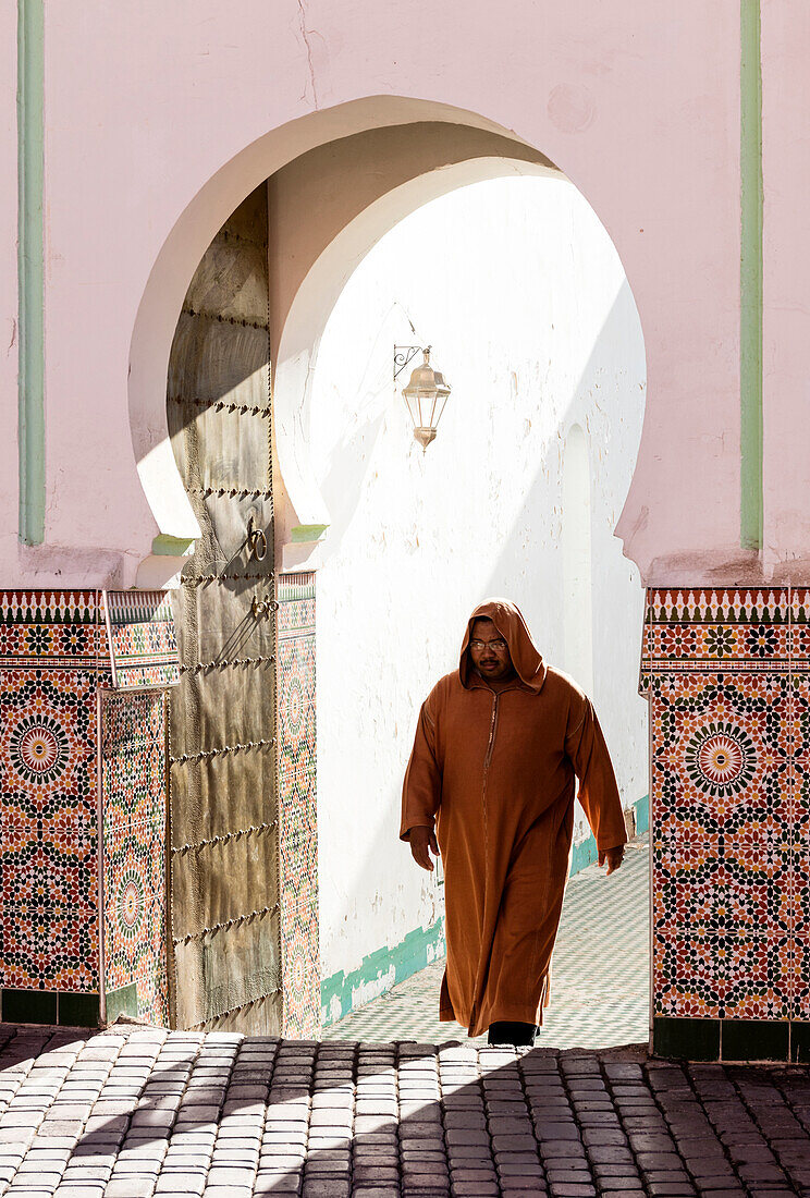 Local man dressed in traditional djellaba walking out of mosque in the Kasbah, Marrakech, Morocco, North Africa, Africa