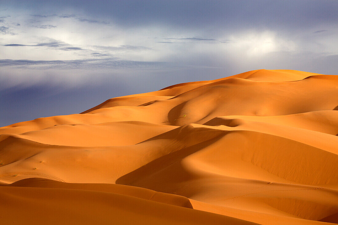 Orange sand dunes against stormy sky, Erg Chebbi sand sea, part of the Sahara Desert near Merzouga, Morocco, North Africa, Africa