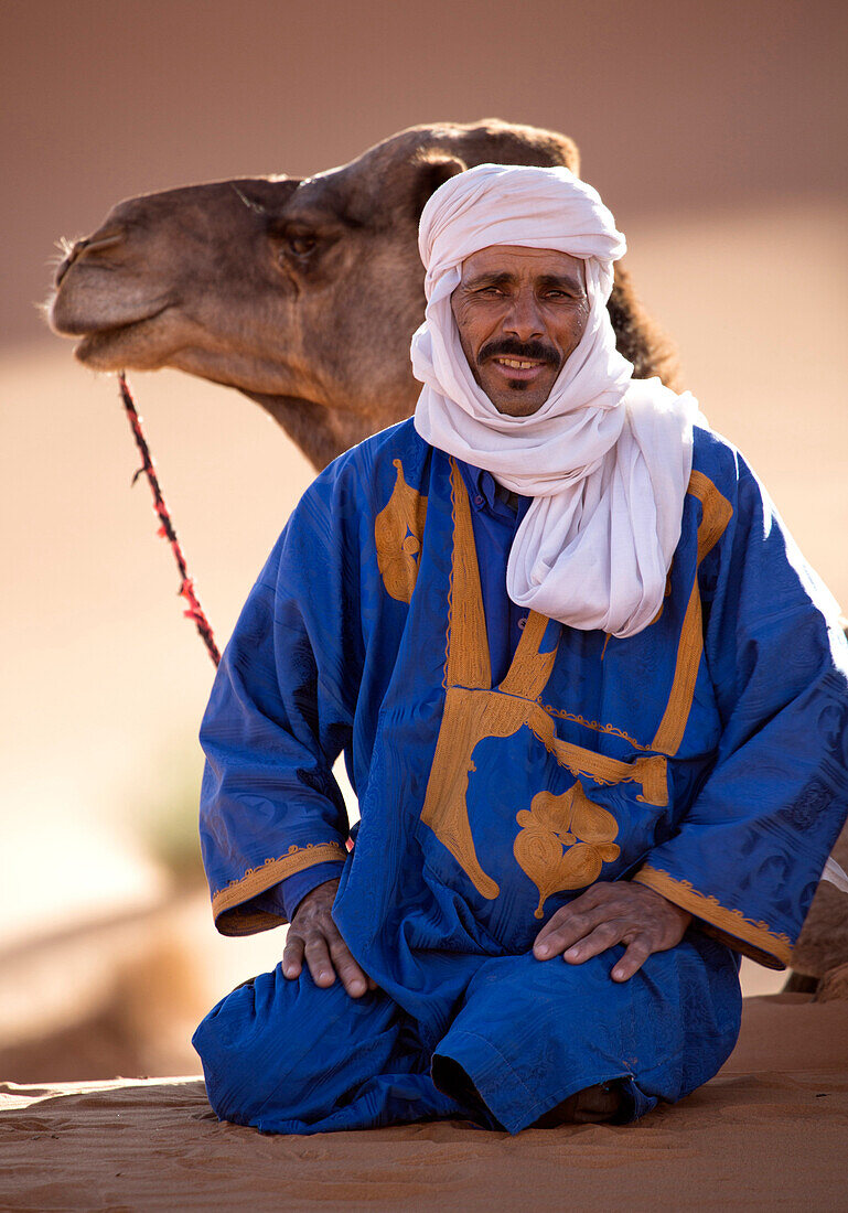 Berber Mann mit Kamel, ruhen in der Erg Chebbi Sand Meer, Teil der Sahara in der Nähe von Merzouga, Marokko, Nordafrika, Afrika