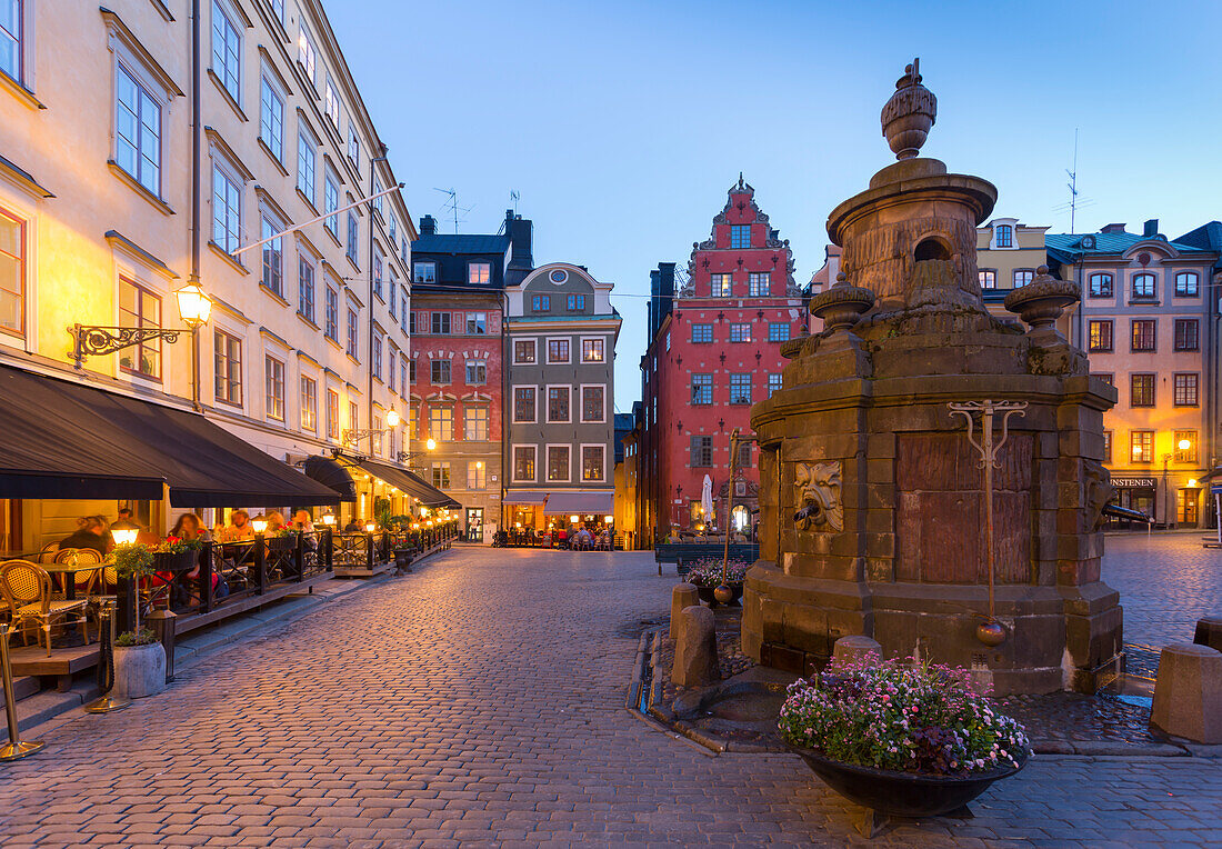 Restaurant and colourful buildings on Stortorget, Old Town Square in Gamla Stan at dusk, Stockholm, Sweden, Scandinavia, Europe