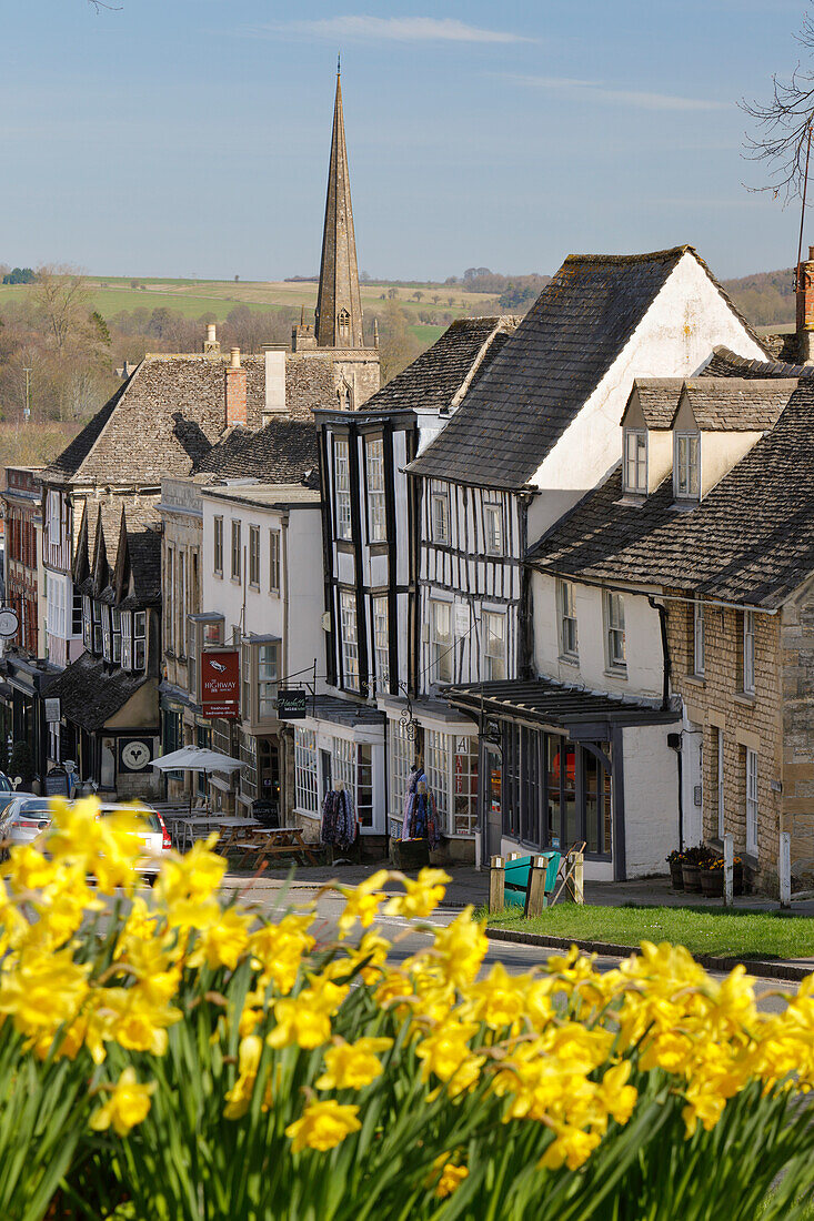 High Street and Burford Church with daffodils, Burford, Cotswolds, Oxfordshire, England, United Kingdom, Europe
