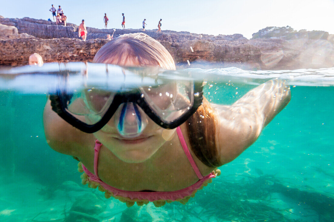 Neun jähriges Mädchen taucht mit der Schnorchelmaske, Cala s’Almunia, Mallorca, Balearische Inseln, Spanien