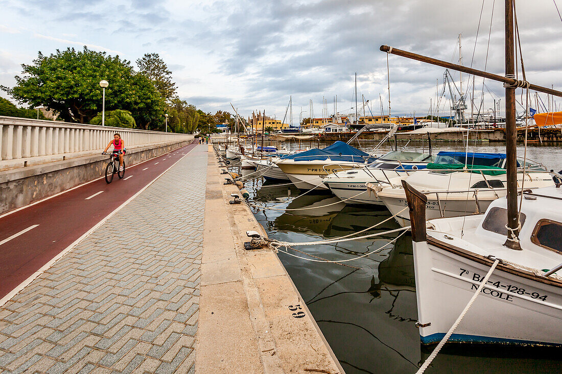 Luxus-Yachten un Radfahrerin im Hafen von Palma, Mallorca, Spanien, Europa