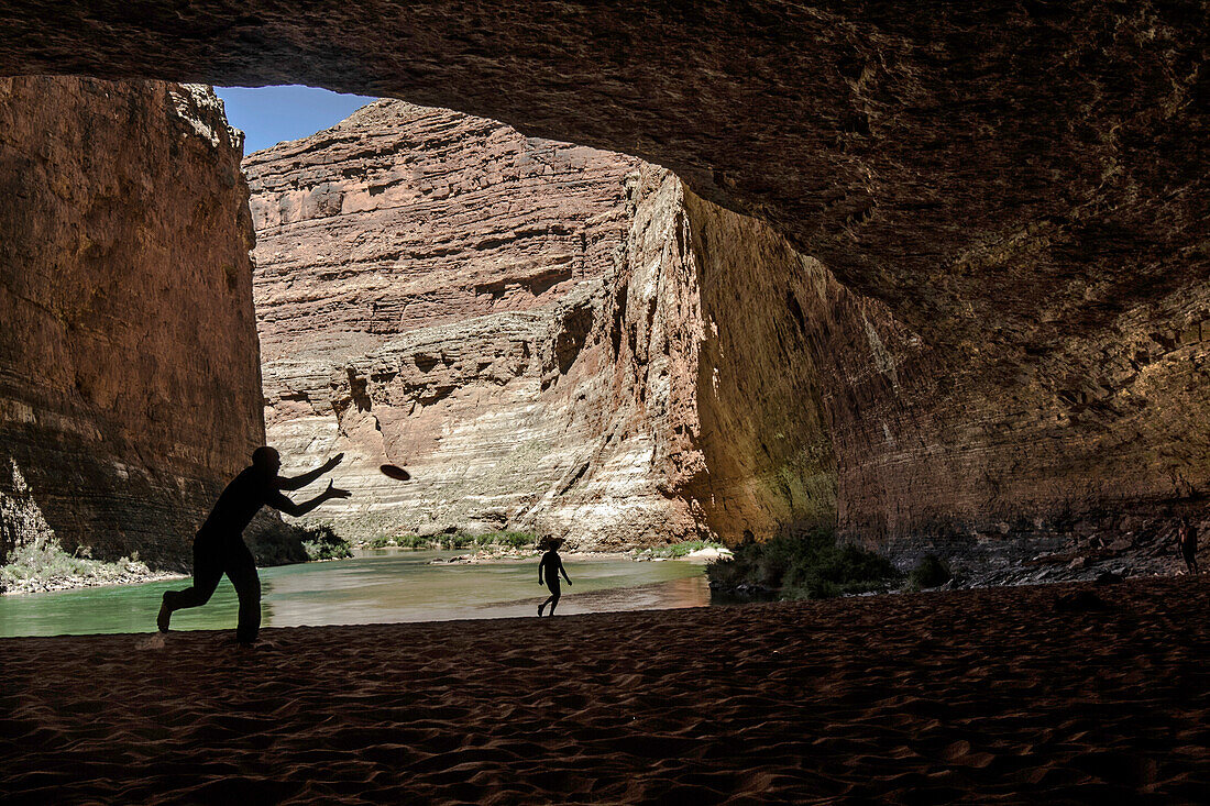 Two Men play pass in a cave in the Grand Canyon