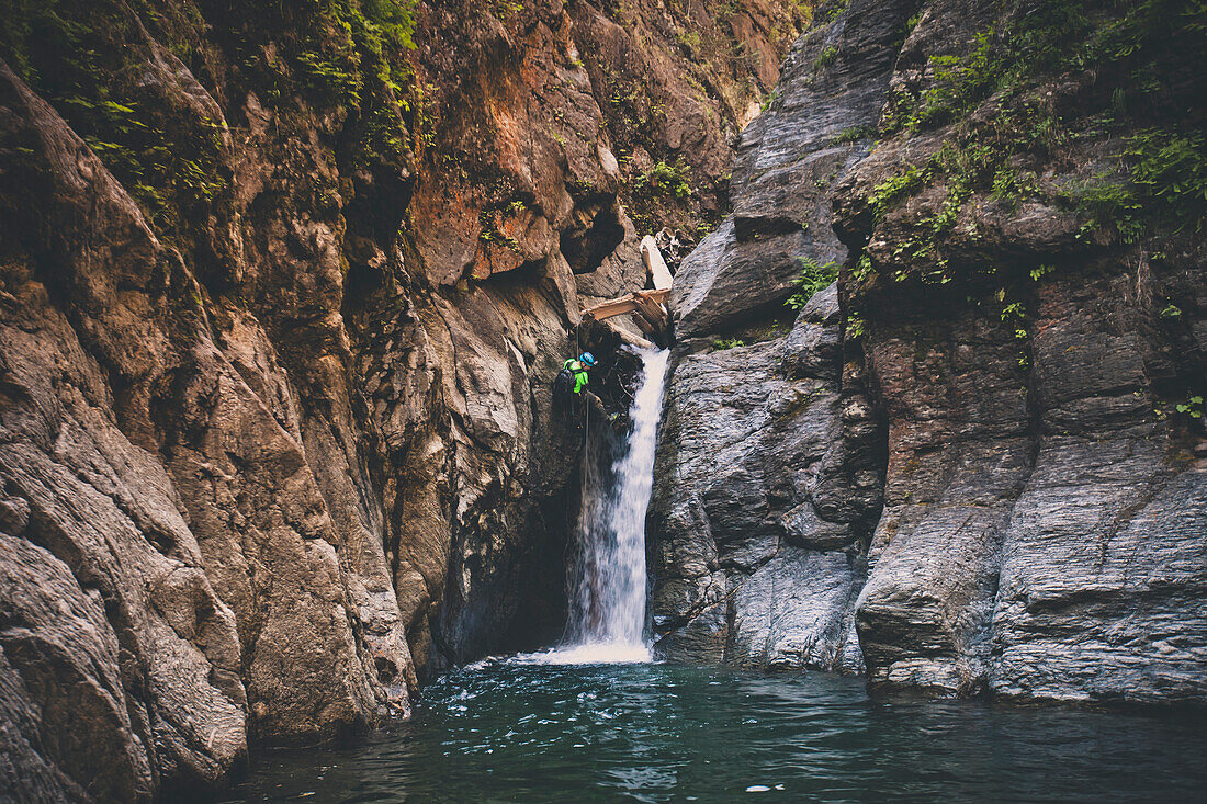 Mann, der weg vom Wasserfall beim canyoneering in Deneau-Nebenfluss, Hoffnung, Britisch-Columbia, Kanada abseilt