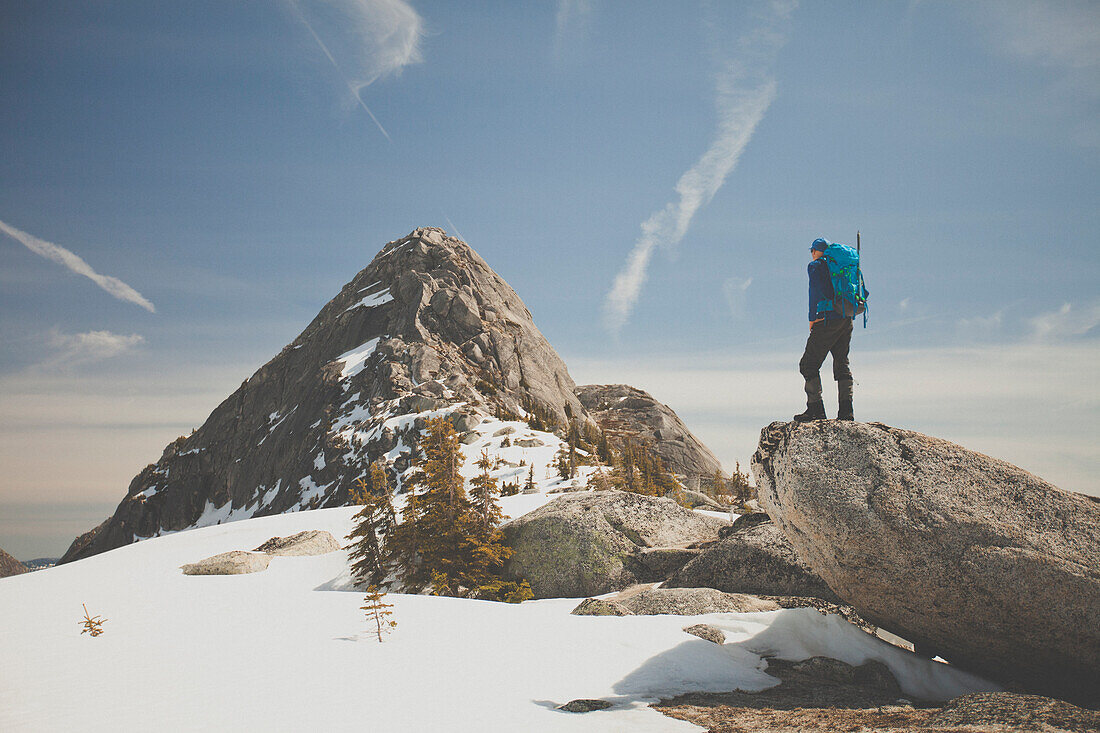 Photograph of hiker looking at view of Needle Peak in winter, British Columbia, Canada
