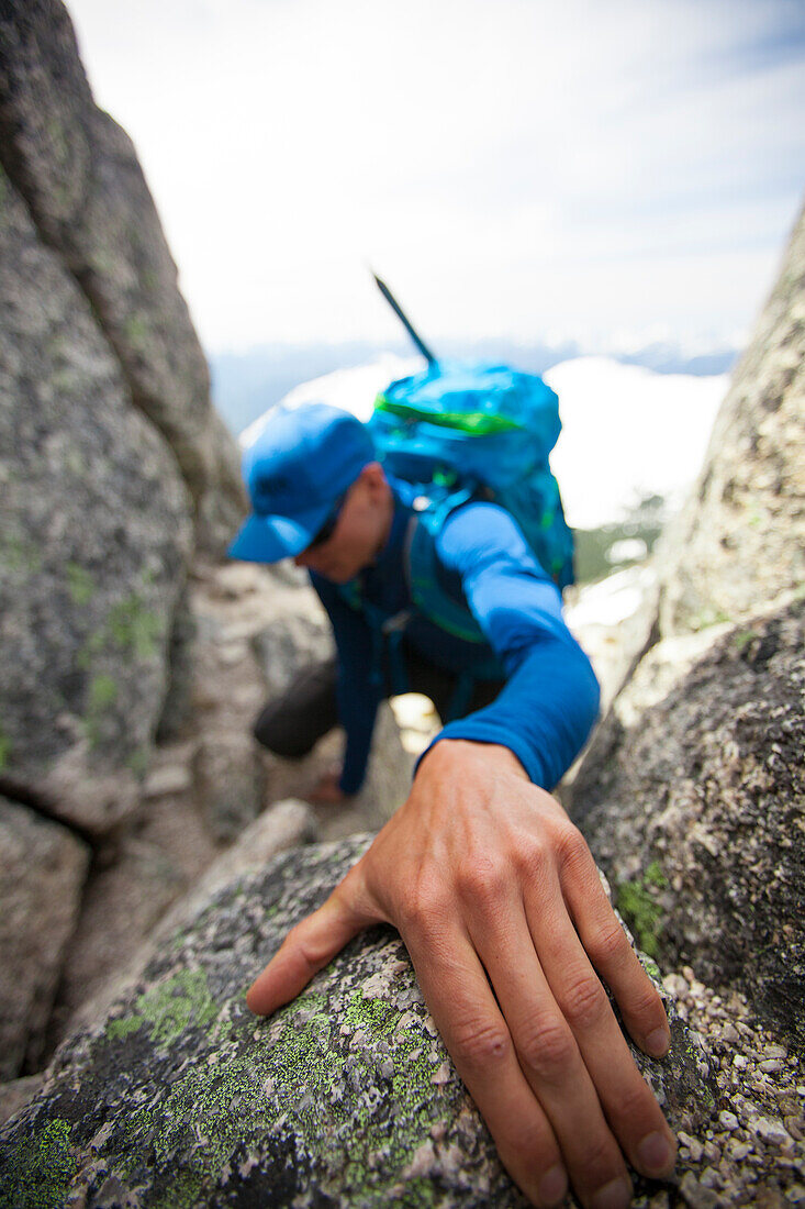 Photograph of male backpacker climbing Needle Peak, Hope, British Columbia, Canada