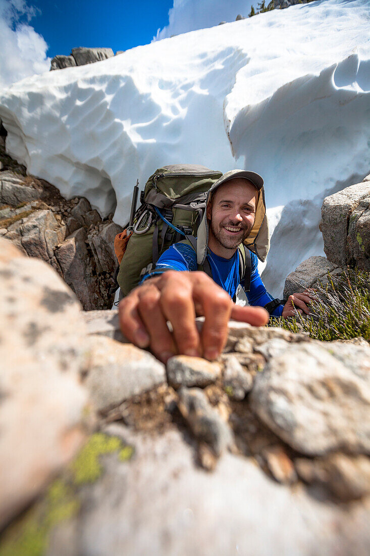 Fotografie des lächelnden Bergsteigers, der Kamera beim Klettern, Chilliwack, Britisch-Columbia, Kanada betrachtet