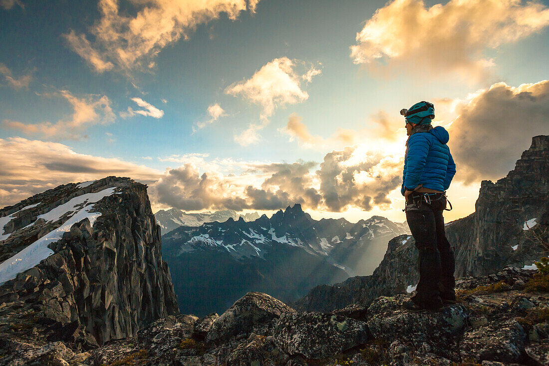 Fotografie des Bergsteigers, der Ansicht in Nordkaskaden-Gebirgszug bei Sonnenuntergang, Chilliwack, Britisch-Columbia, Kanada betrachtet