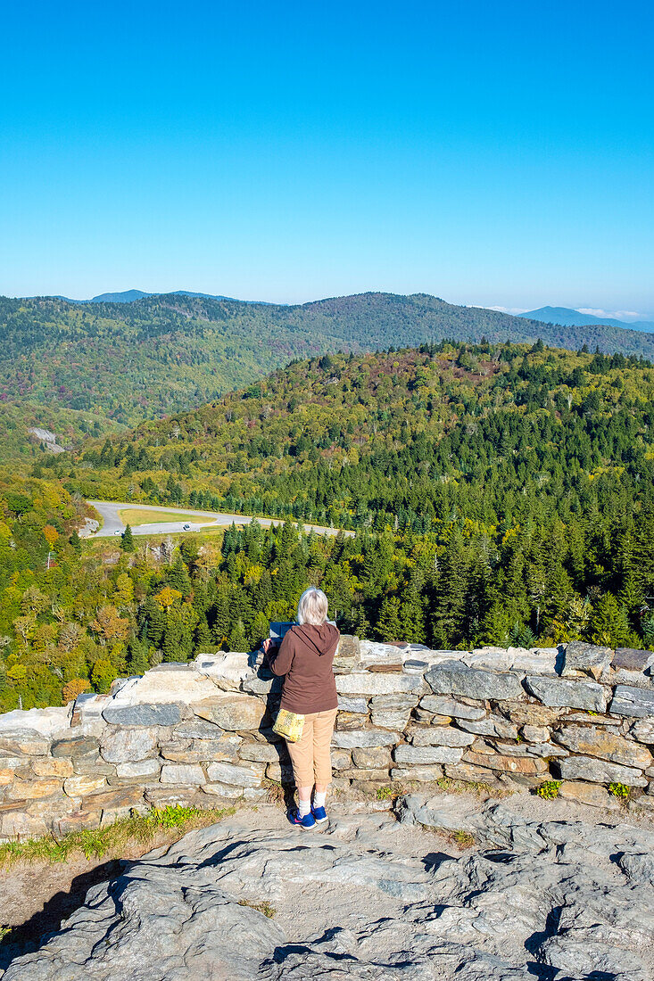 United States, North Carolina, Transylvania County. Woman admiring view of Blue Ridge Mountains from Devil's Courthouse, Blue Ridge Parkway.