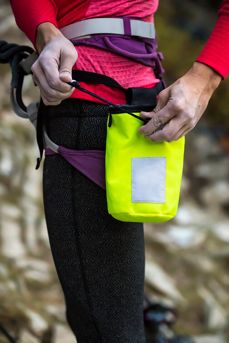 Climber tying chalk bag, Wyoming, USA