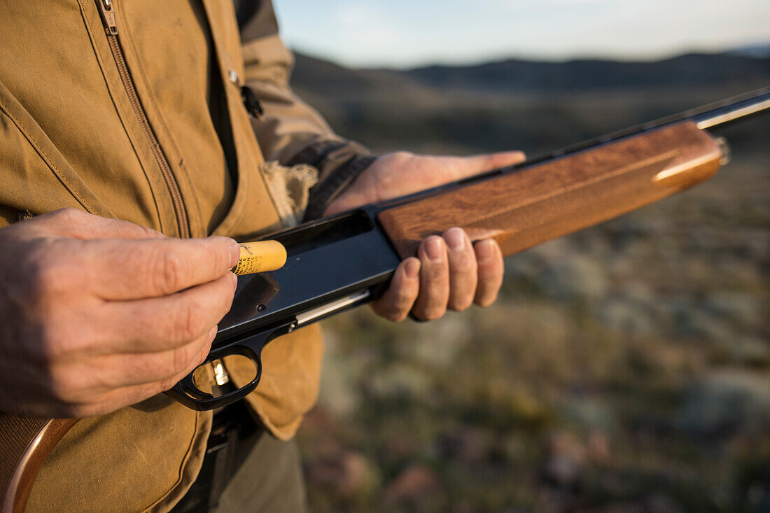 Mann geht durch das Nevada Backcountry, das Chukar jagt.