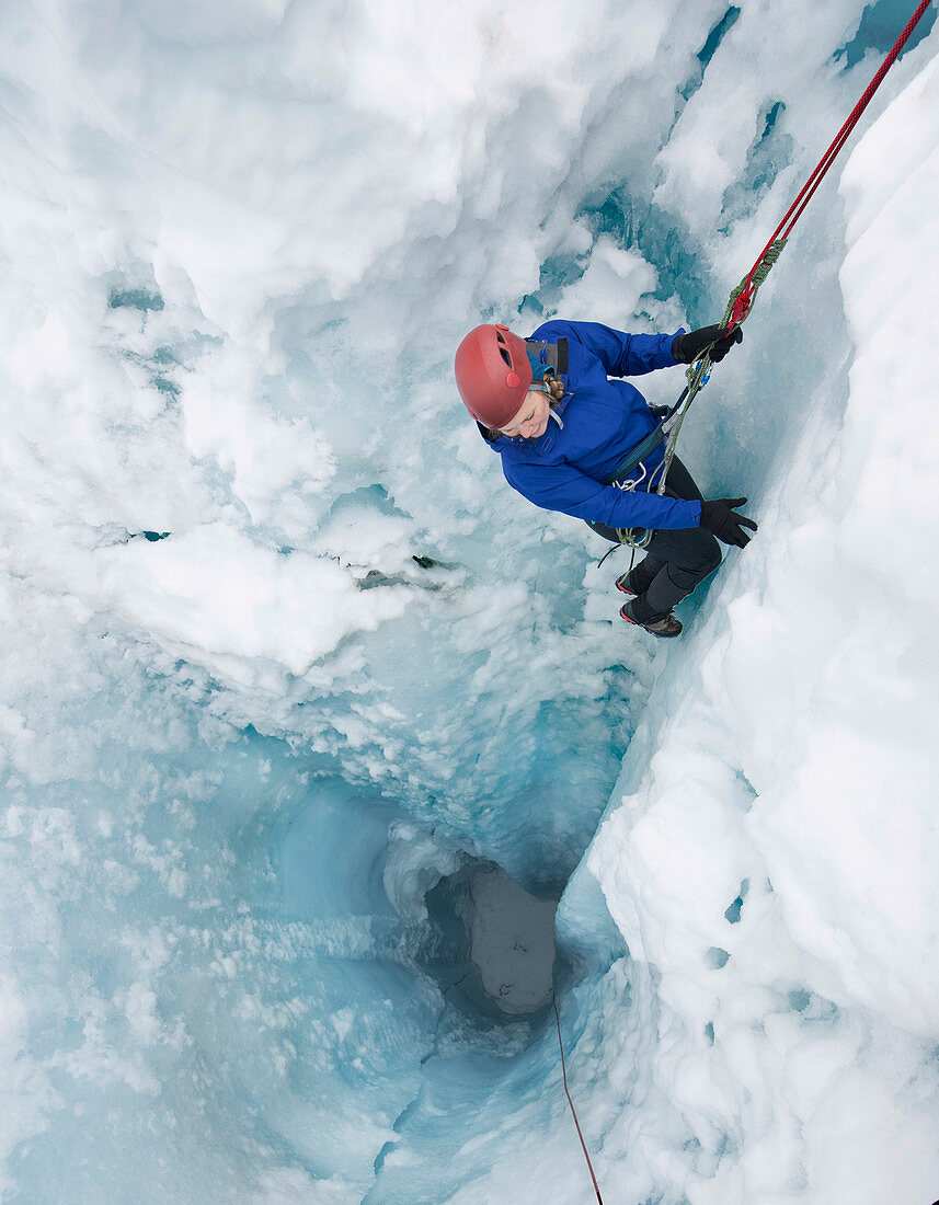 Photograph of adventurous woman rappelling into moulin on Coleman Glacier on Mount Baker, Washington State, USA
