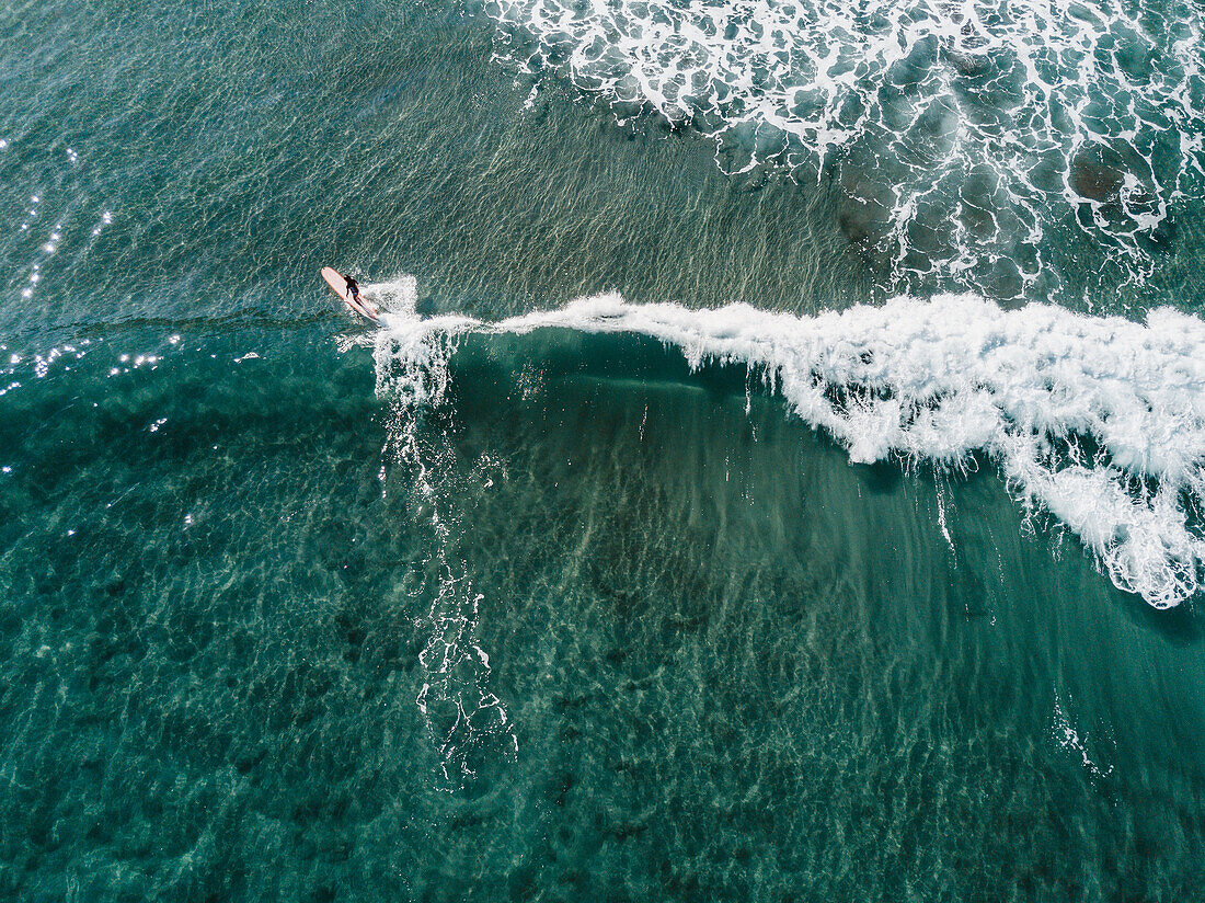 Vogelperspektive des weiblichen Surfers surfend in klares Meer, Teneriffa, Kanarische Inseln, Spanien