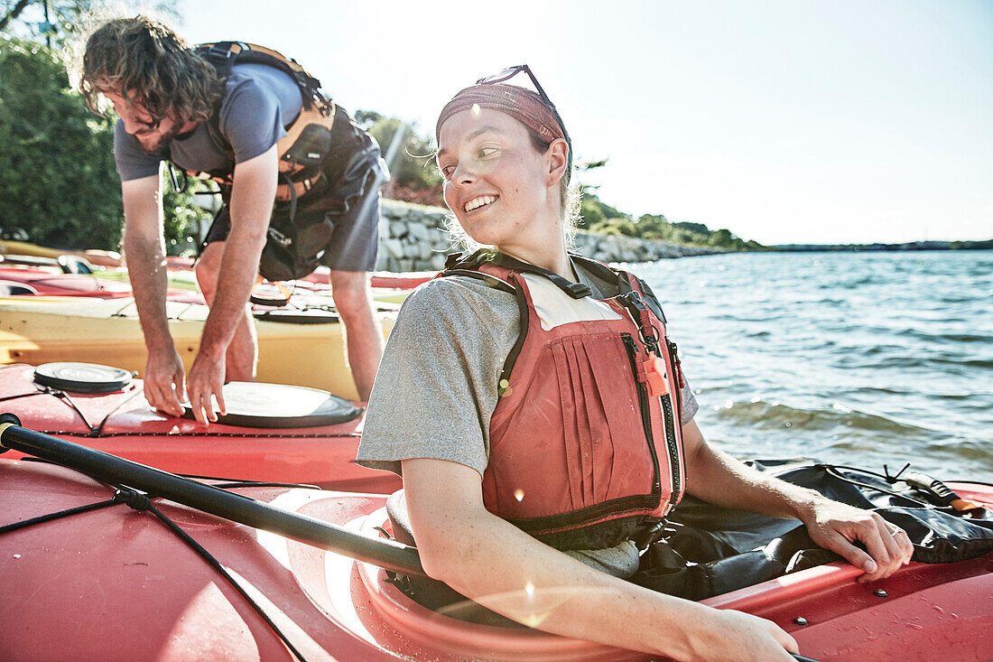Photograph of young woman looking back at tandem kayak partner, Portland, Maine, USA