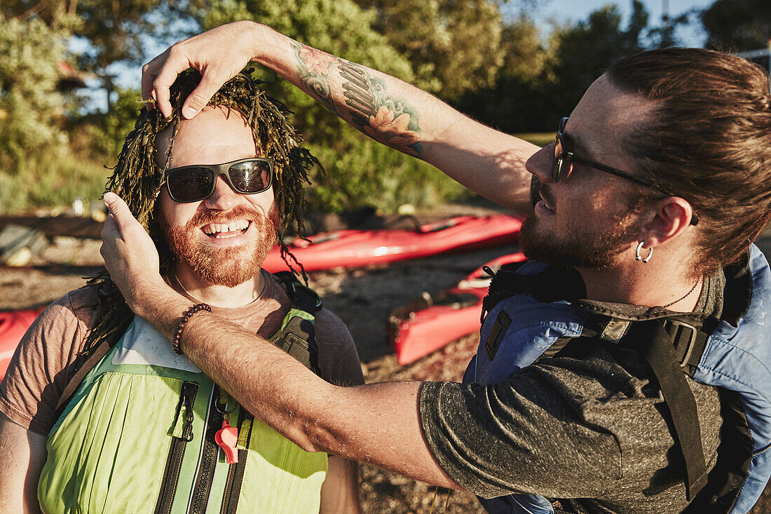Photograph of two friends having fun with seaweed, Portland, Maine, USA
