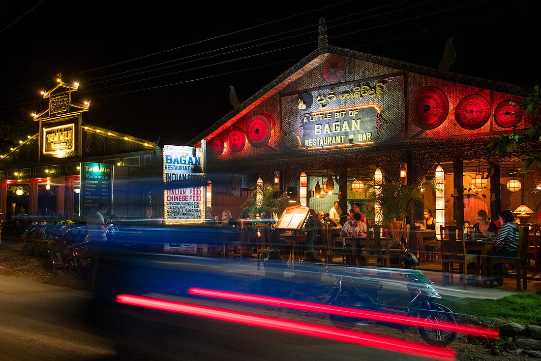Light streaks of car passing A Little Bit of Bagan restaurant and bar at night, Nyaung-U, near Bagan, Mandalay, Myanmar