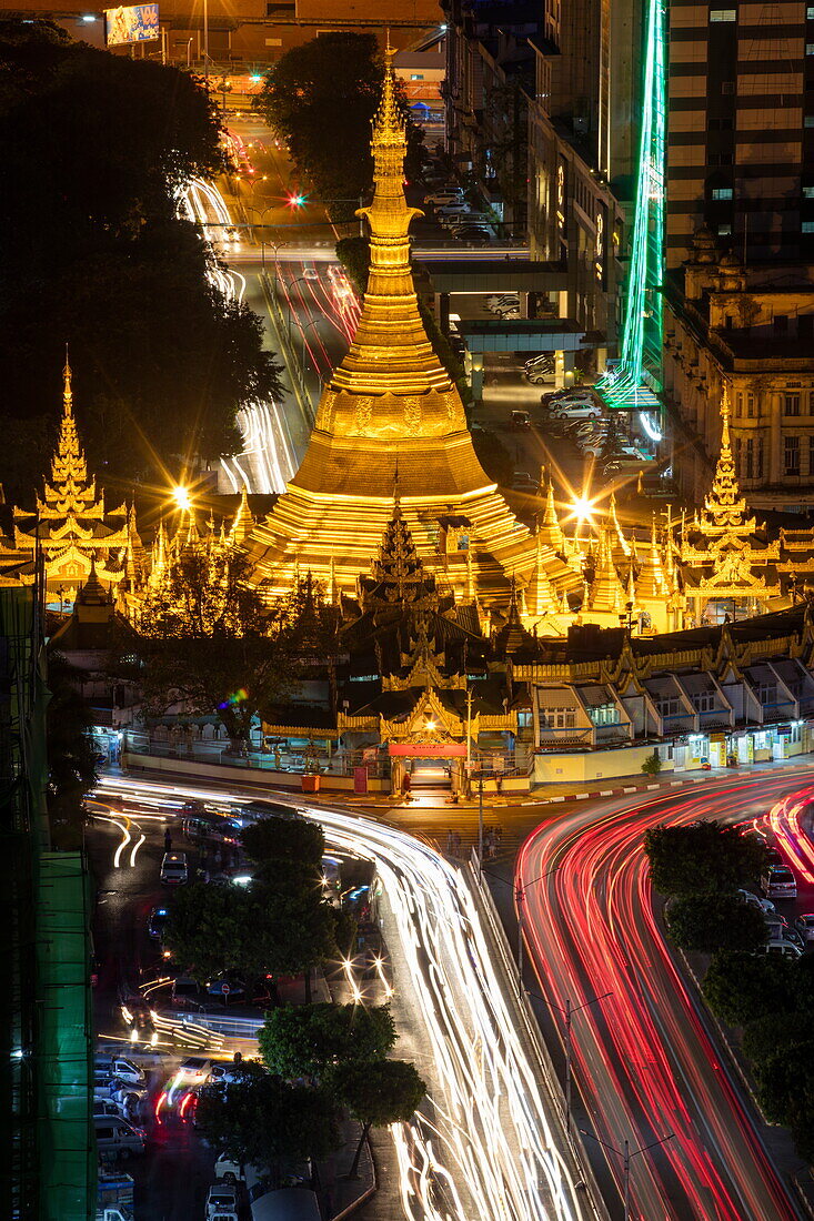 Overhead of illuminated Sule Pagoda and streaks of car lights on Sule Pagoda Road seen from Sakura Tower at night, Yangon, Yangon, Myanmar