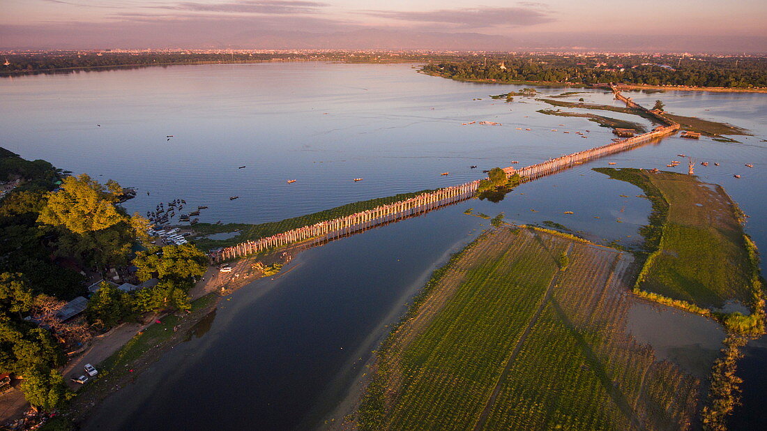 Luftaufnahme von Touristen auf der U-Bein-Brücke und in Ruderbooten auf dem Taungthaman See bei Sonnenuntergang, Amarapura, Mandalay, Myanmar
