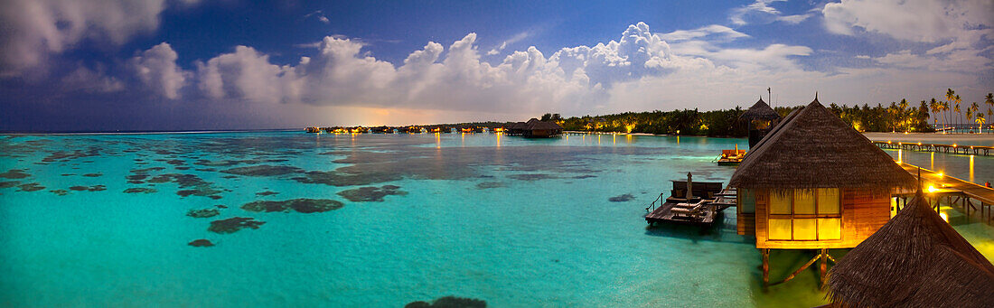 Panoramic view of overwater villas under the moonlight at Gili Lankanfushi, on the Maldives.
