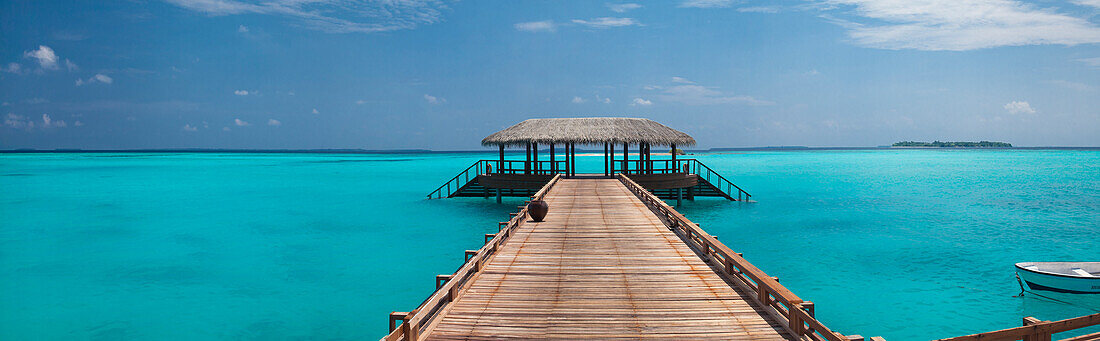 Tropical resort with stilt hut at the end of the pier in the sea