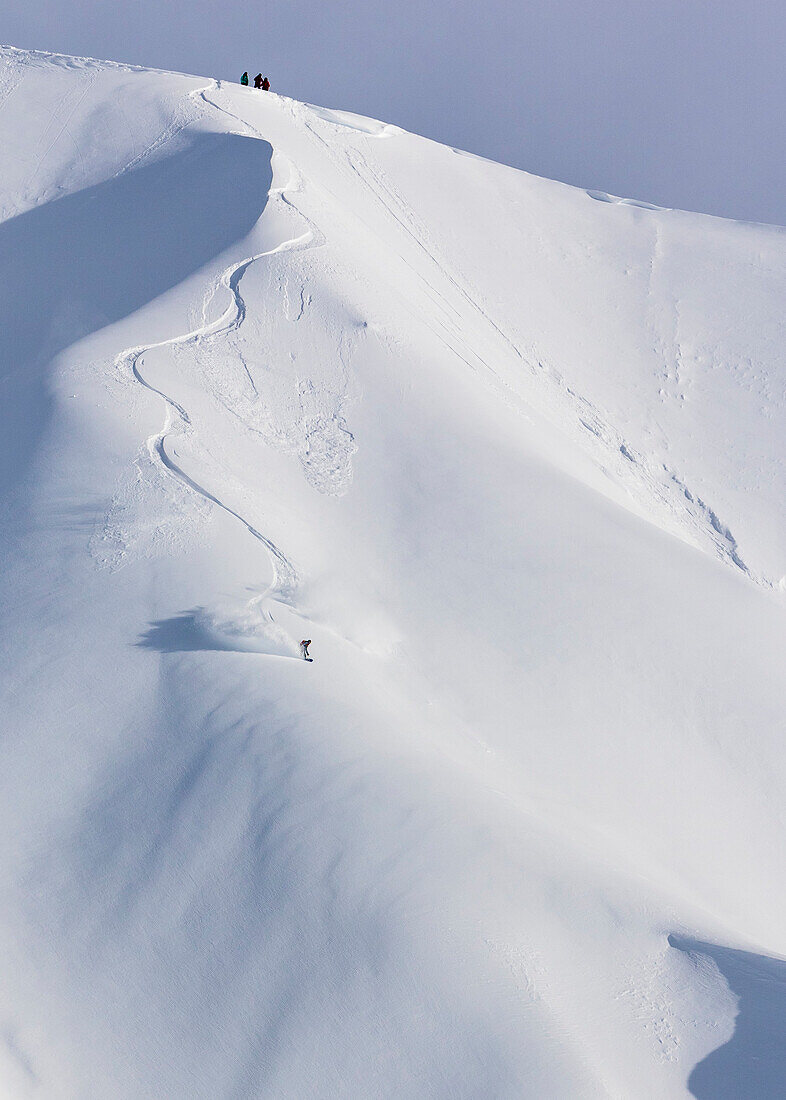 Professioneller Snowboarder Robin Van Gyn, reitet frisches Puder an einem sonnigen Tag beim Snowboarding in Haines, Alaska.