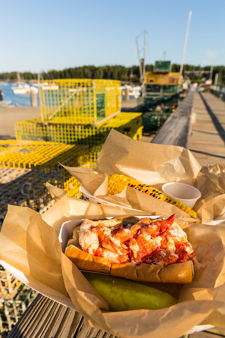 A lobster roll and corn on the dock behind restaurant on Miller's Wharf, Tenants Harbor, Maine