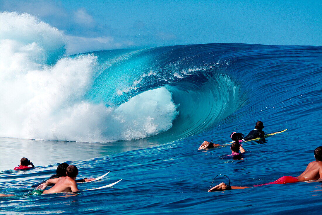 Surfer auf dem Surfbrett, das einen perfekten Wellenbruch bei Teahupoo, Tahiti aufpasst